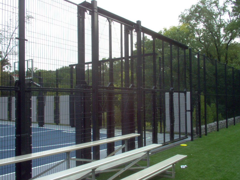 an aluminum gate surrounding a basketball court