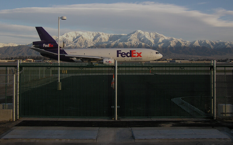 FedEx airplane behind security gate at airport