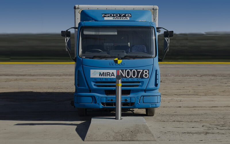 Truck behind crash bollard at test site
