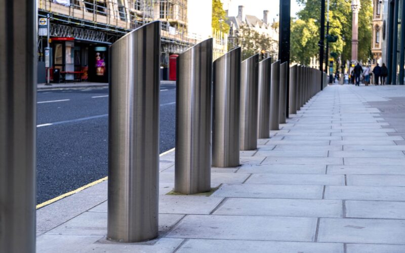 silver crash bollards on a sidewalk for protection