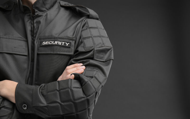 security guard in a black jacket standing with arms crossed