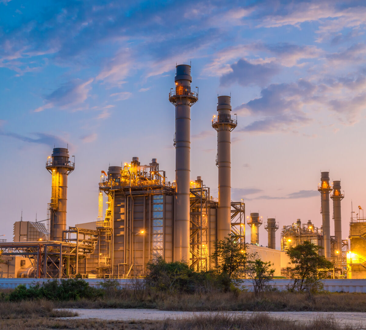 A chemical plant is gently illuminated against a dusky sky