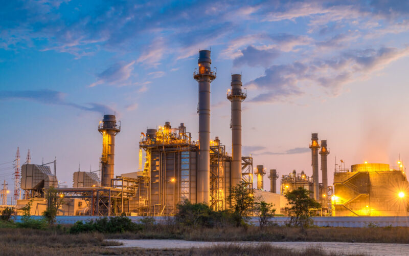 A chemical plant is gently illuminated against a dusky sky